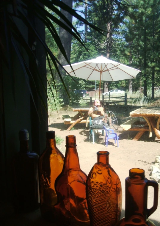 a view from inside a tent looking out to someone sitting on a bench