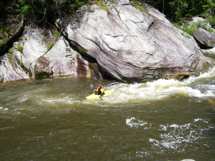 a man on a paddle paddling across a river