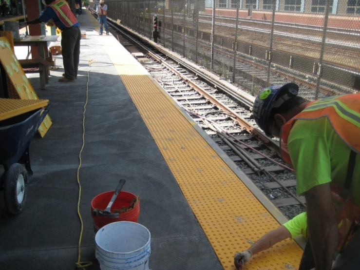 the railroad worker is making repairs for the train tracks