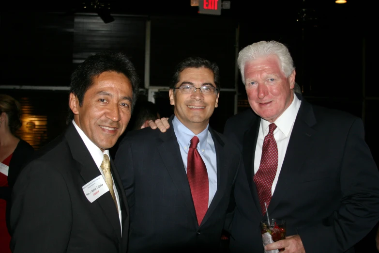 three men wearing suit and ties posing for the camera