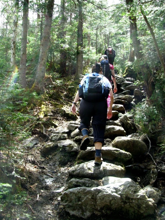 a group of people with backpacks are climbing up the rocks