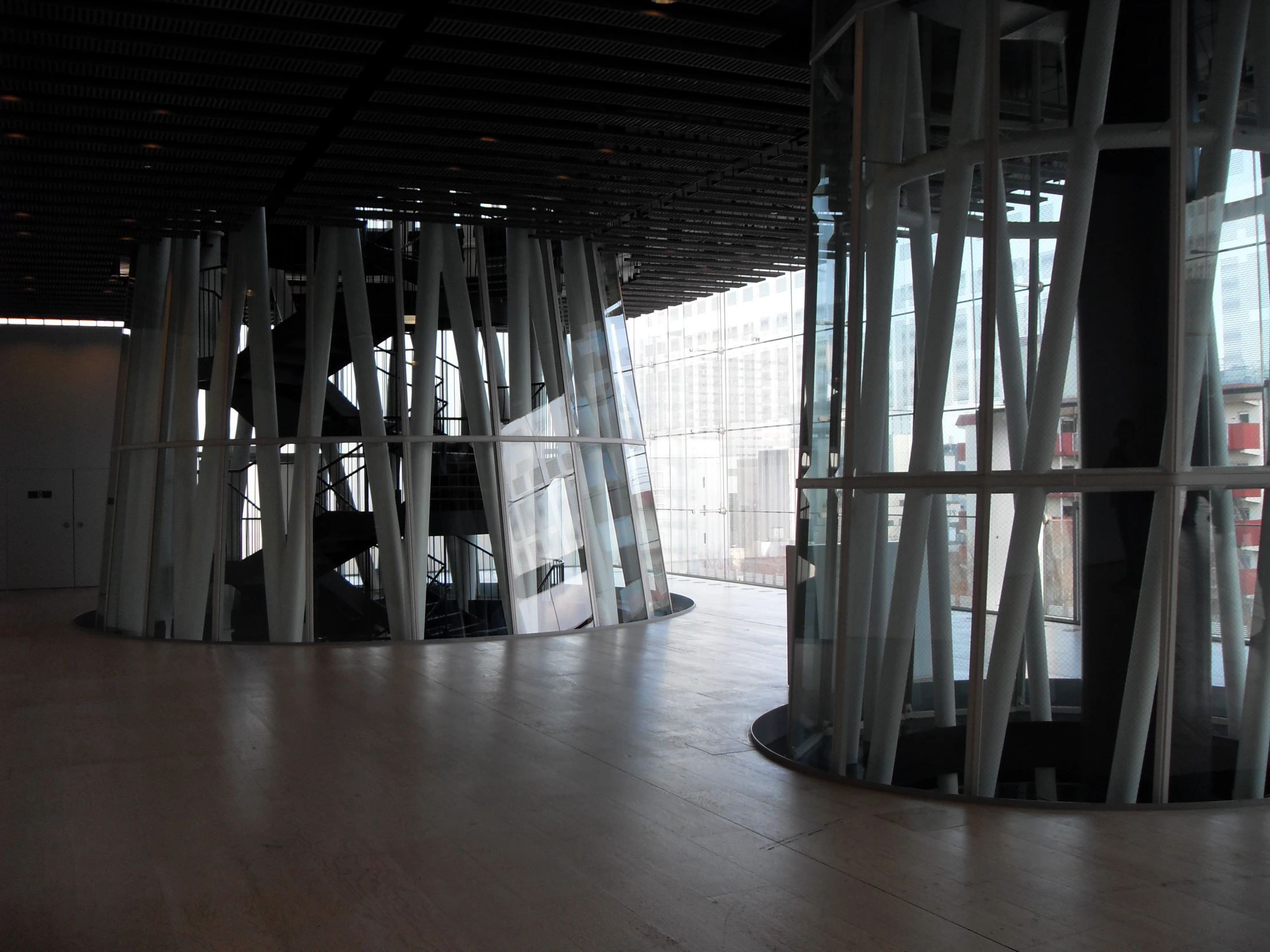 an open building with wooden columns and glass windows