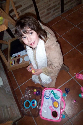 a girl kneeling on the floor with many toy items