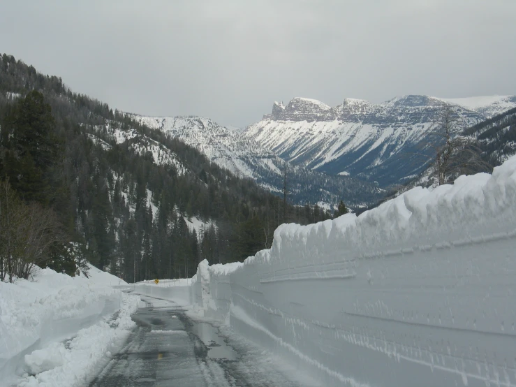 a person riding a snowboard on a snowy mountain road