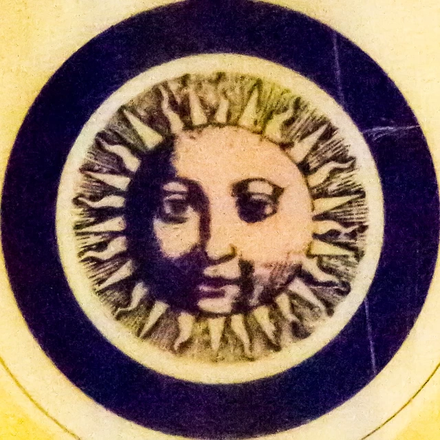 there is a circular painted plate with an image of the face