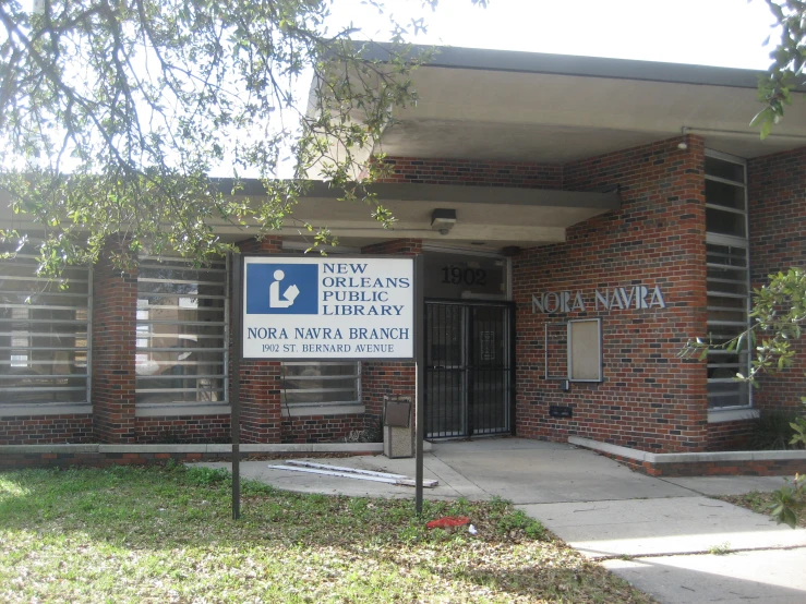 the front entrance of a building with a sign in the front