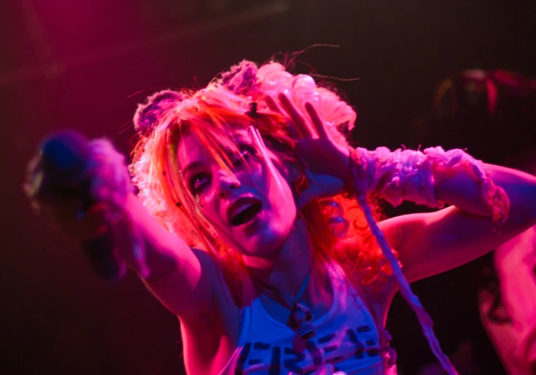 a woman on stage is singing while people watch