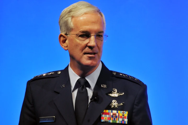 a close - up view of an official man in military clothes, wearing a tie and glasses