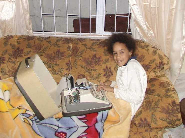 a  sitting on a couch next to a laptop computer