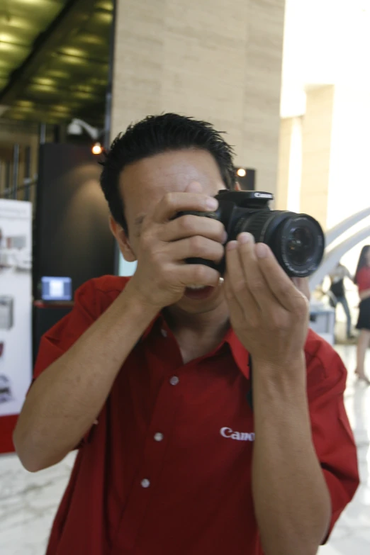 a man that is holding a camera up to his face