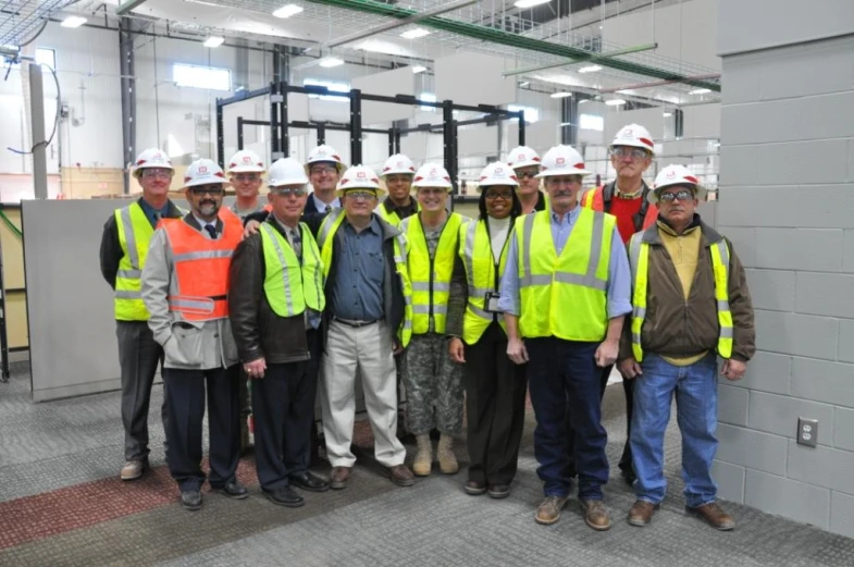 some people standing together wearing vests and hard hats