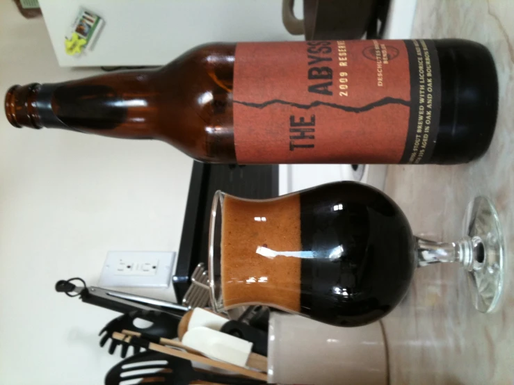 there is a large bottle of wine and two small bottles with tongs