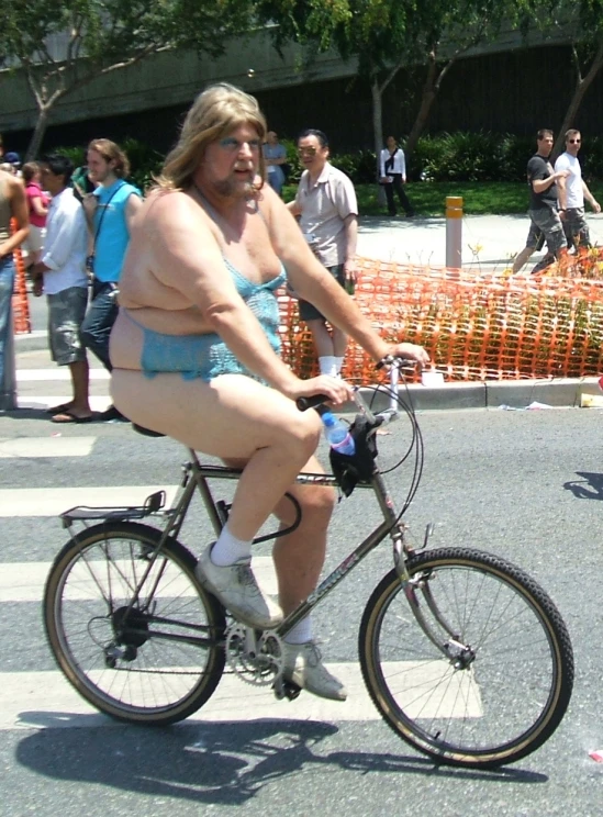 a man in underwear rides a bike on a road