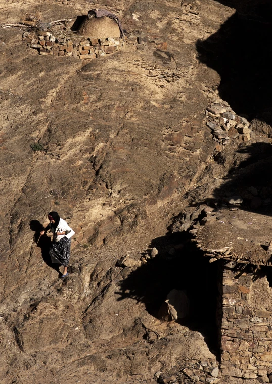 two climbers on a mountain are climbing down the cliff