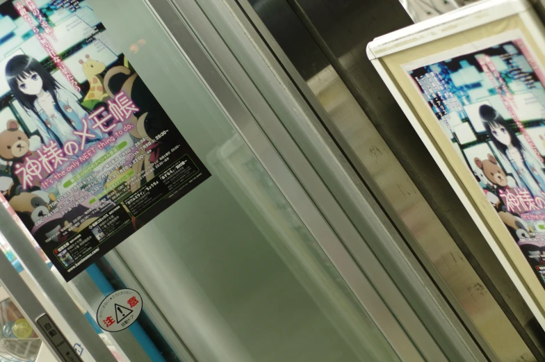 posters on a wall above the entrance of an elevator