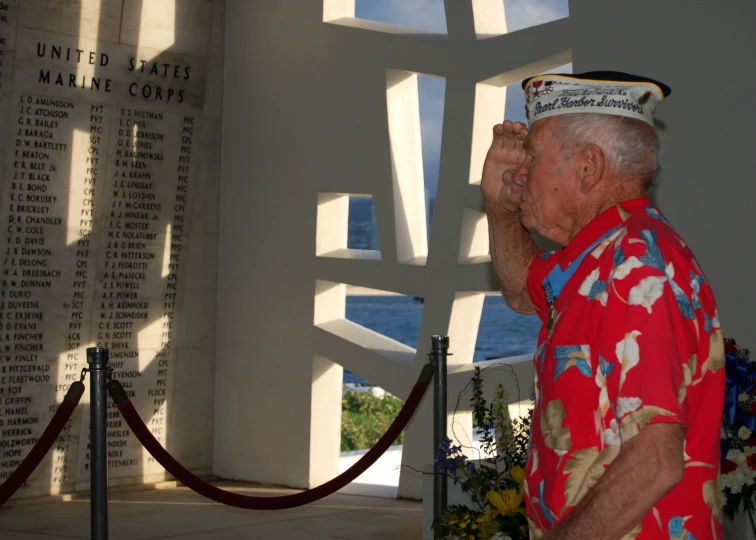 a sailor in a red shirt standing near a sign