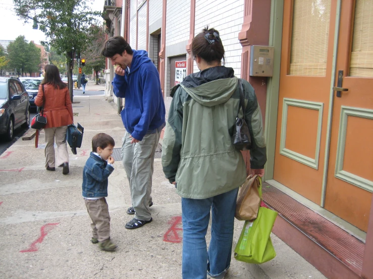 two women and one man walking down a sidewalk