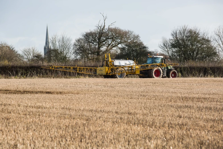 an image of a tractor and trailer being used in the fields