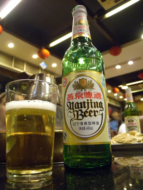 beer bottle next to glass on the table