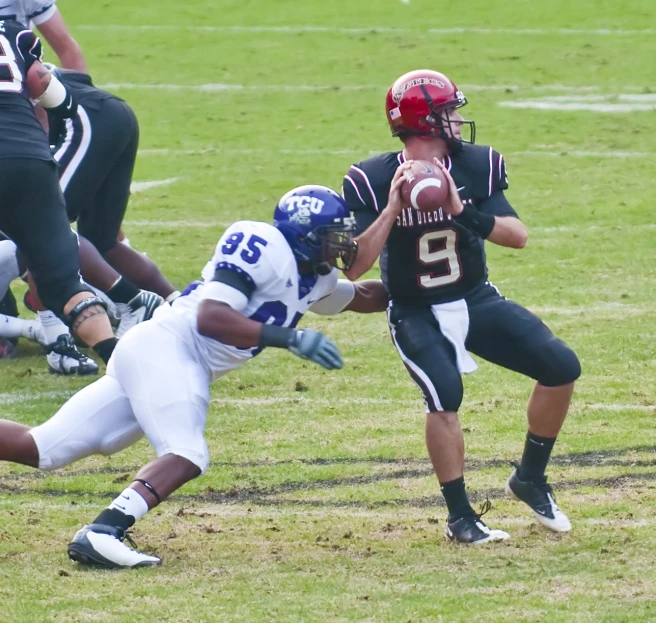 a football player is in midair as another holds the ball