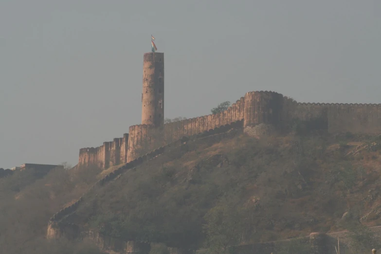 a clock tower stands high on top of a hill