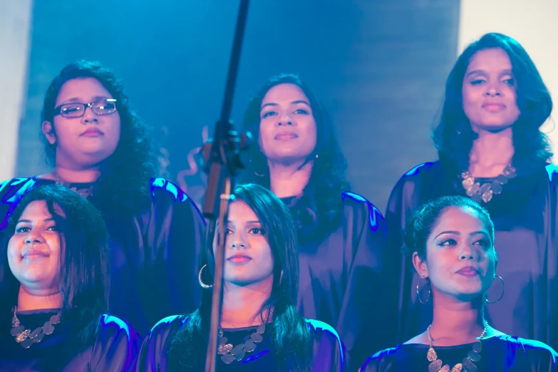 several women singing together with a microphone in their hand