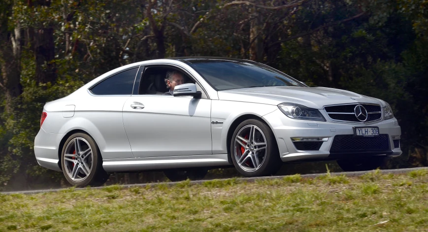 a white mercedes cls with a black tire rim