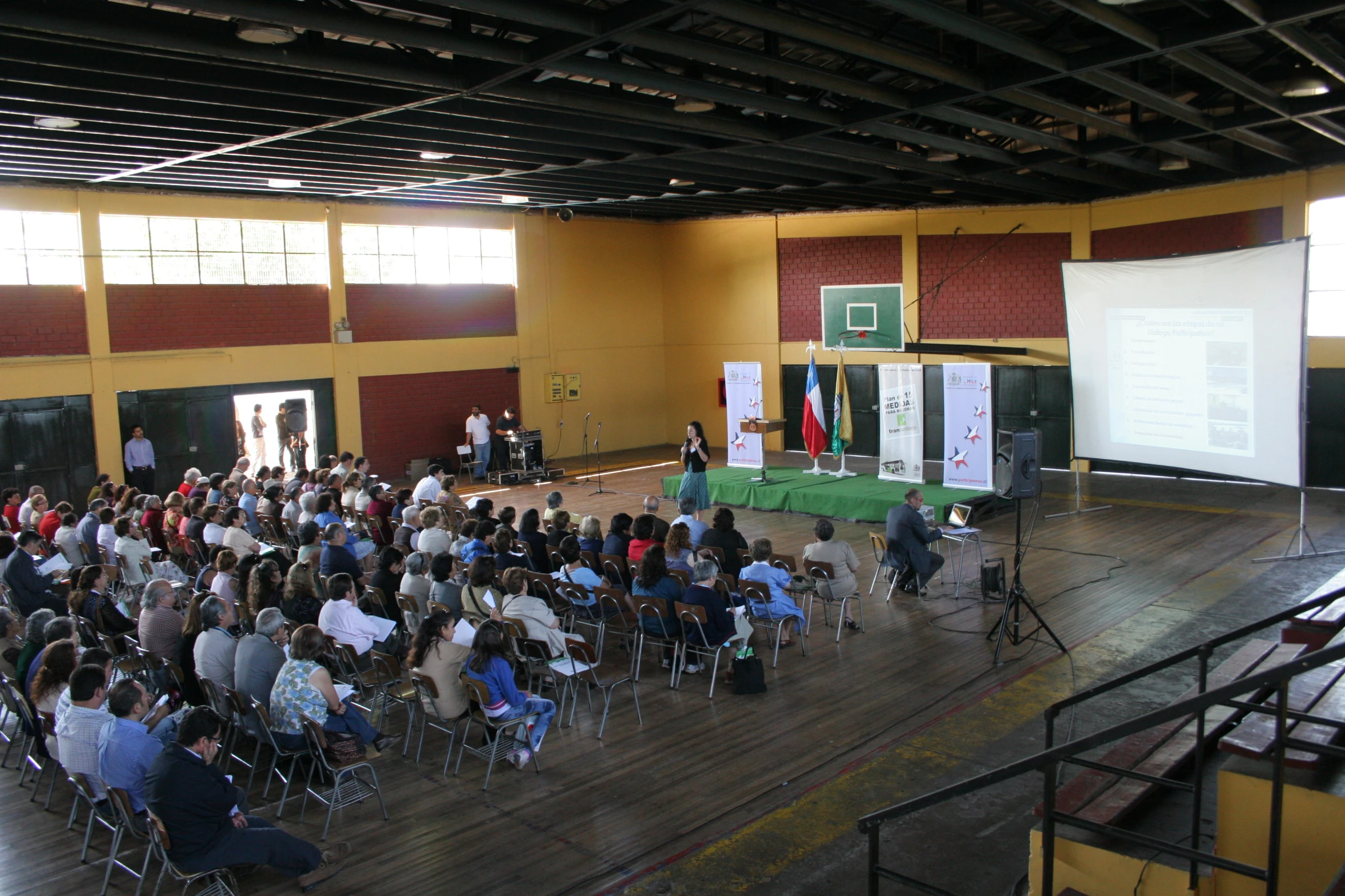 large audience sitting in large auditorium watching speaker