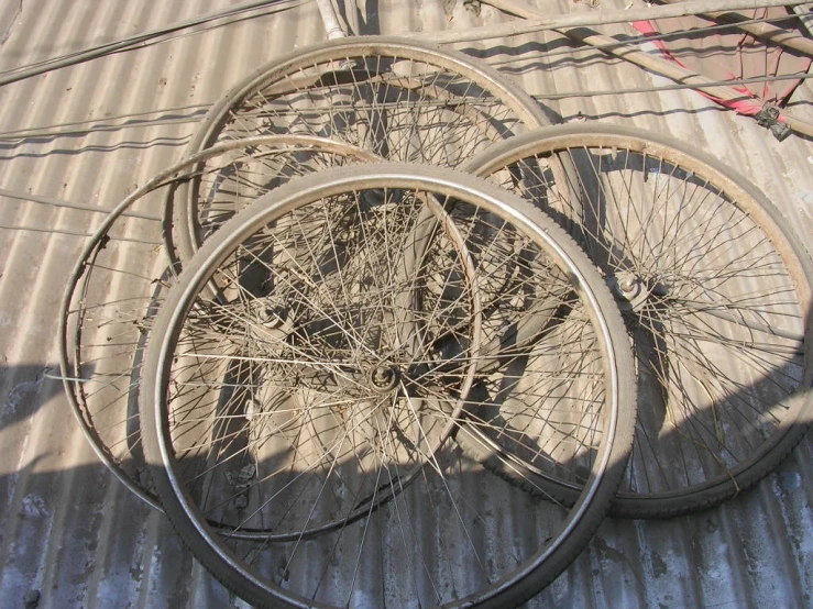 three bicycles are parked side by side on the pavement