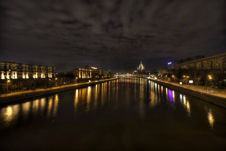 a river with a small town lit up by lights on top of it