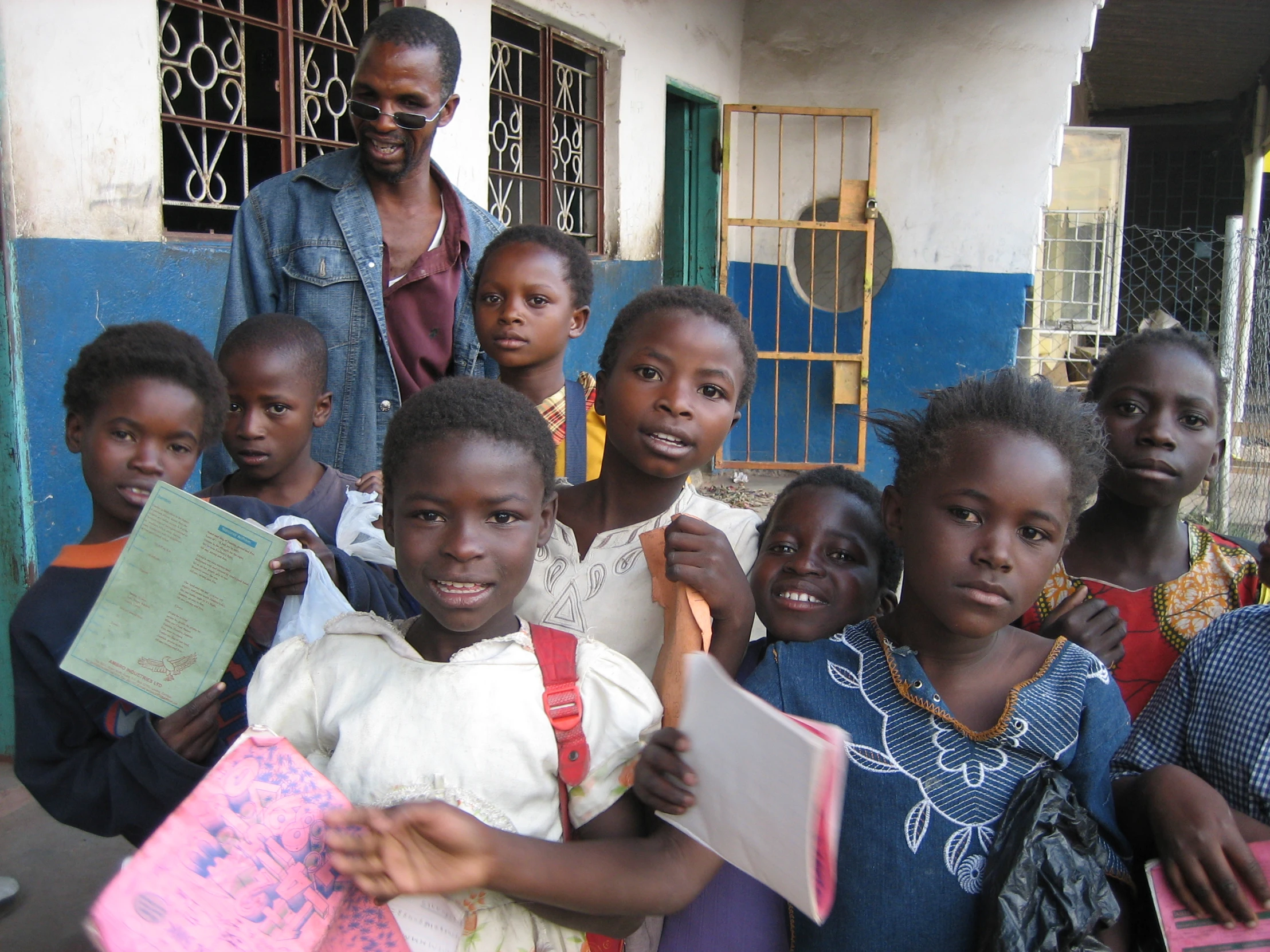 group of children standing in a line in front of blue building