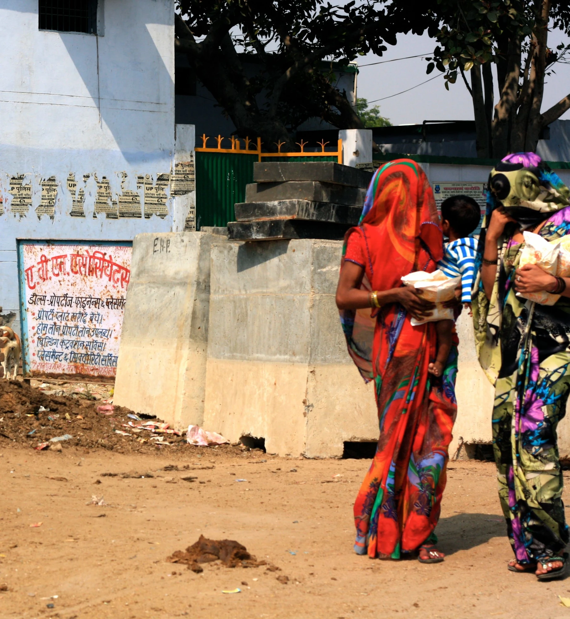 two woman dressed in sari walk next to one another