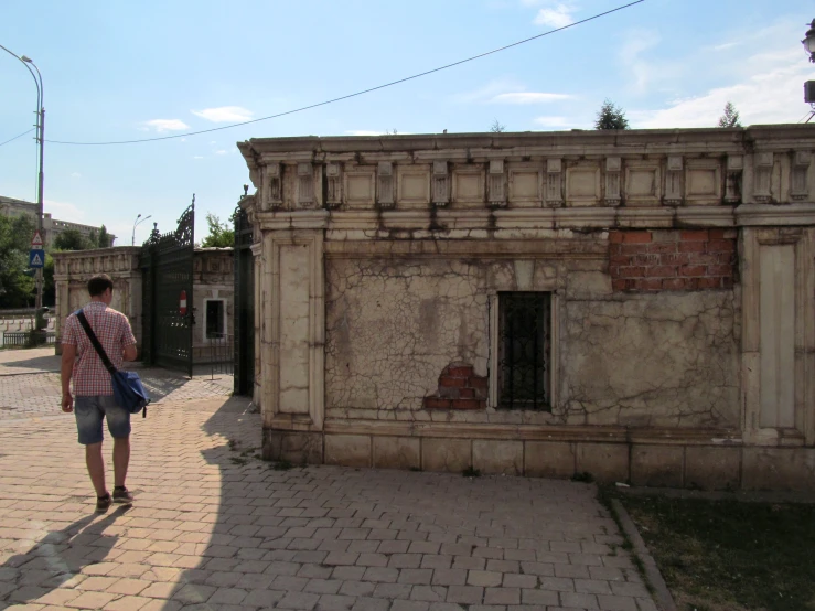 a man walking along side of an old building