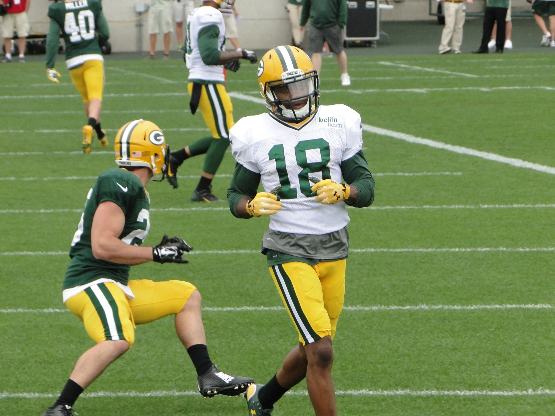 some green and white football players running on a field