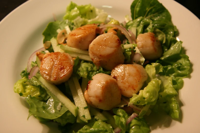this plate has a scallop salad with green vegetables