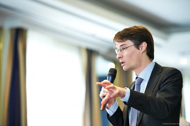 a man is holding a microphone and making a speech