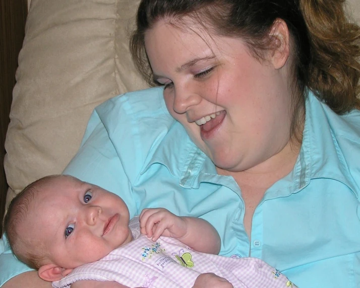 the woman is holding a baby who is smiling