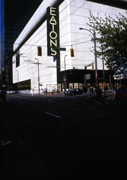 an empty road with cars driving in front of a tall building