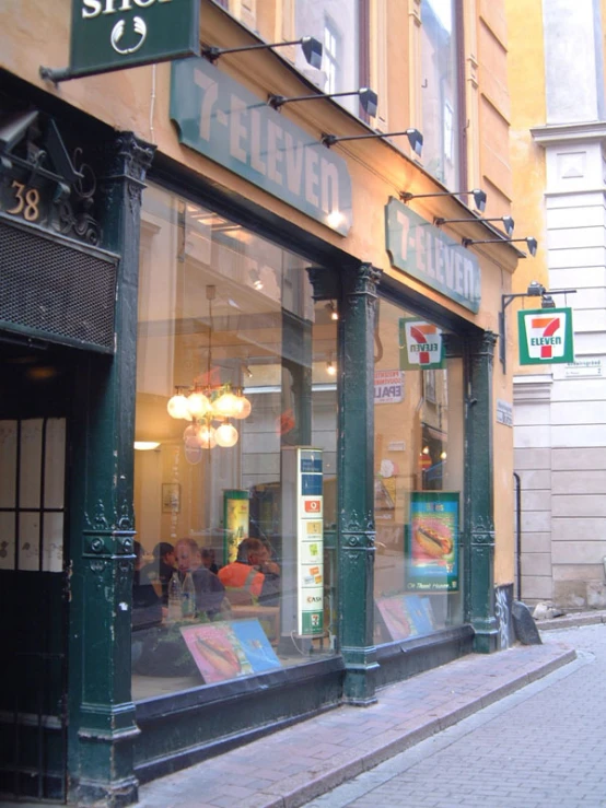an exterior view of a store with large green signs and windows