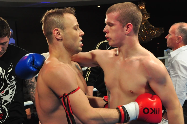 one man holding a boxing ball with a man in his right arm