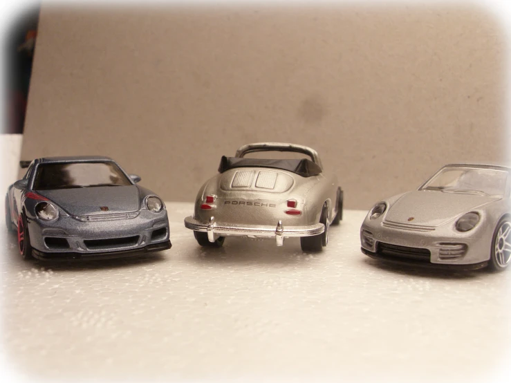 four toy cars lined up on top of a counter