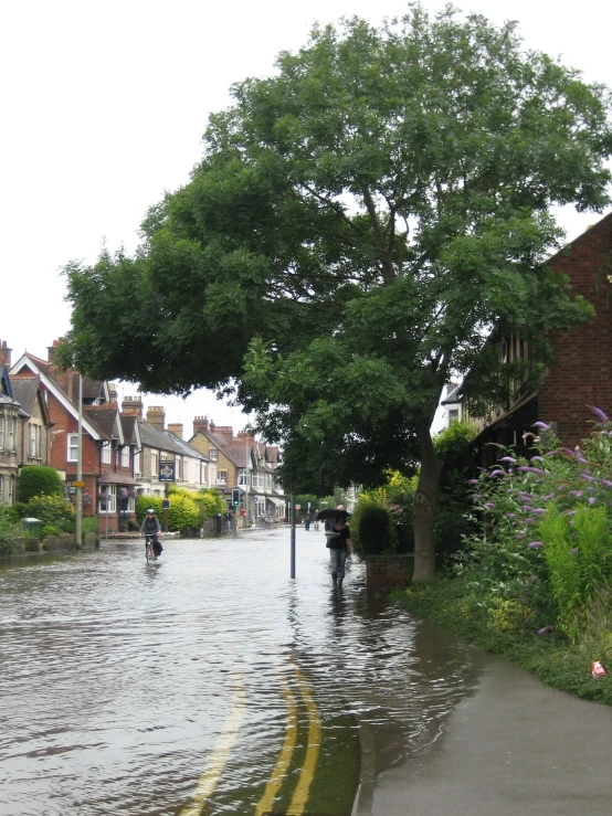 people ride in a boat down a flooded city street