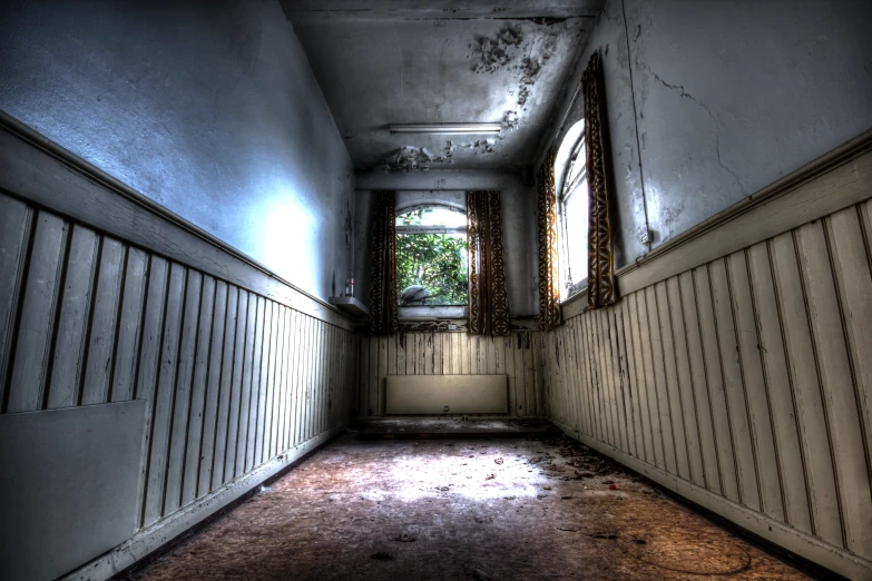 an empty hallway with curtains and a dirty floor