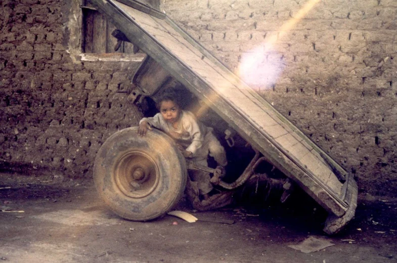 a boy is standing on a huge piece of metal