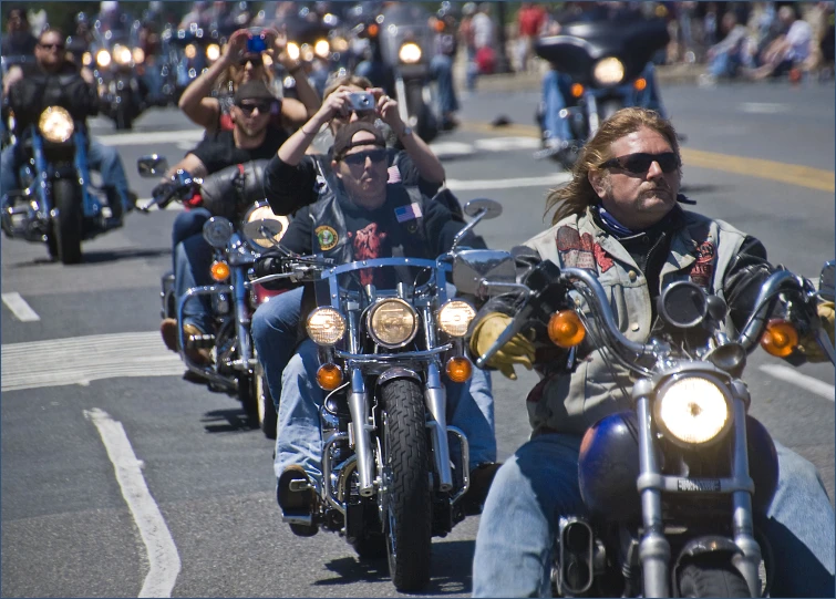 a group of people riding motorcycles on a street