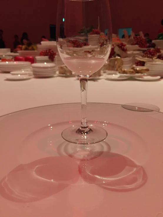 a wine glass sitting on top of a white table