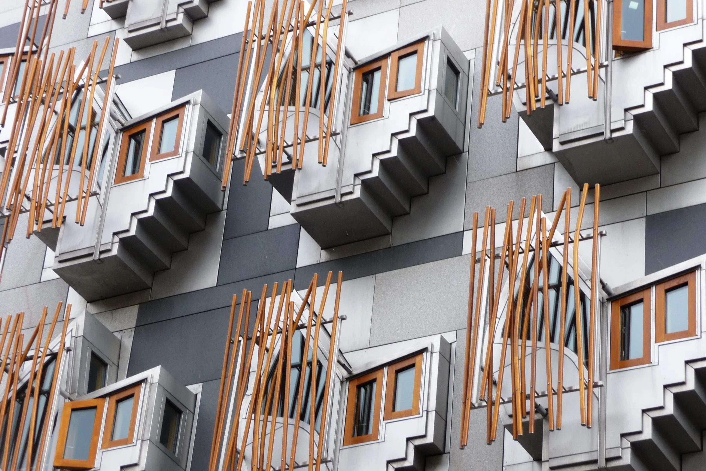 a grey wall with orange windows and wooden slats