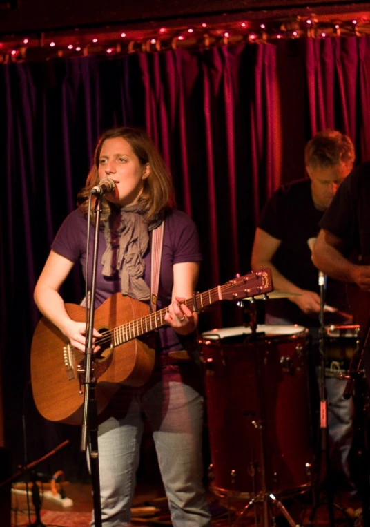 a woman playing an acoustic instrument at a live event