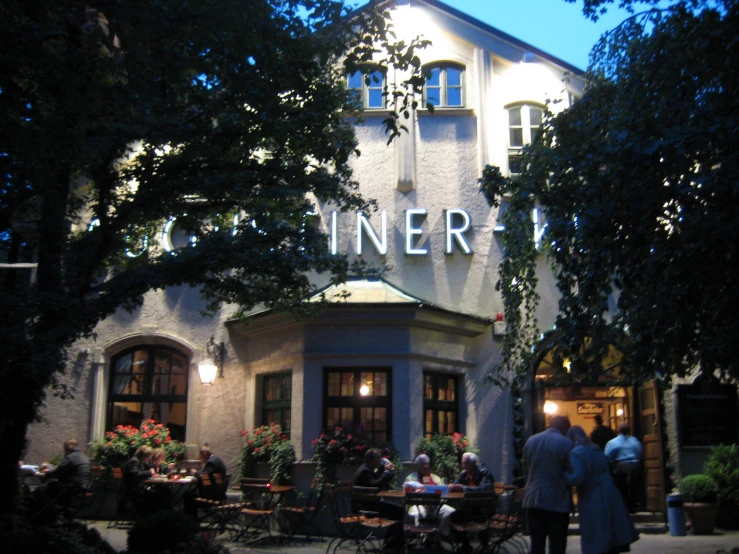 two people are standing outside an inn at night