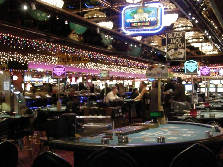 people are standing and sitting at casino tables